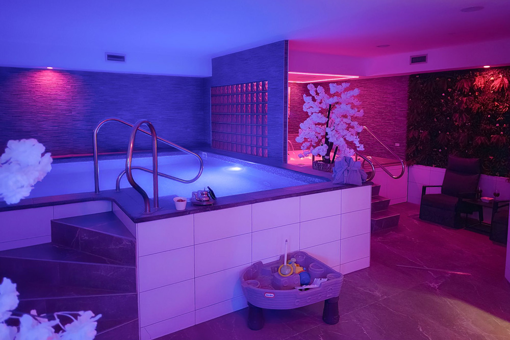 zwembad met kinderspeeltje ervoor en jacuzzi
